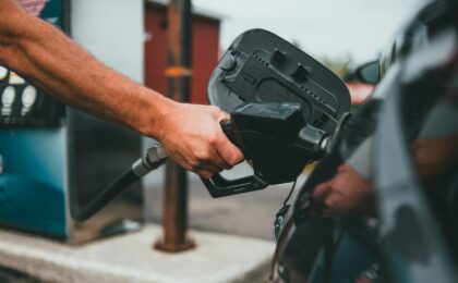 Заправочный пистолет вставлен в топливную горловину автомобиля